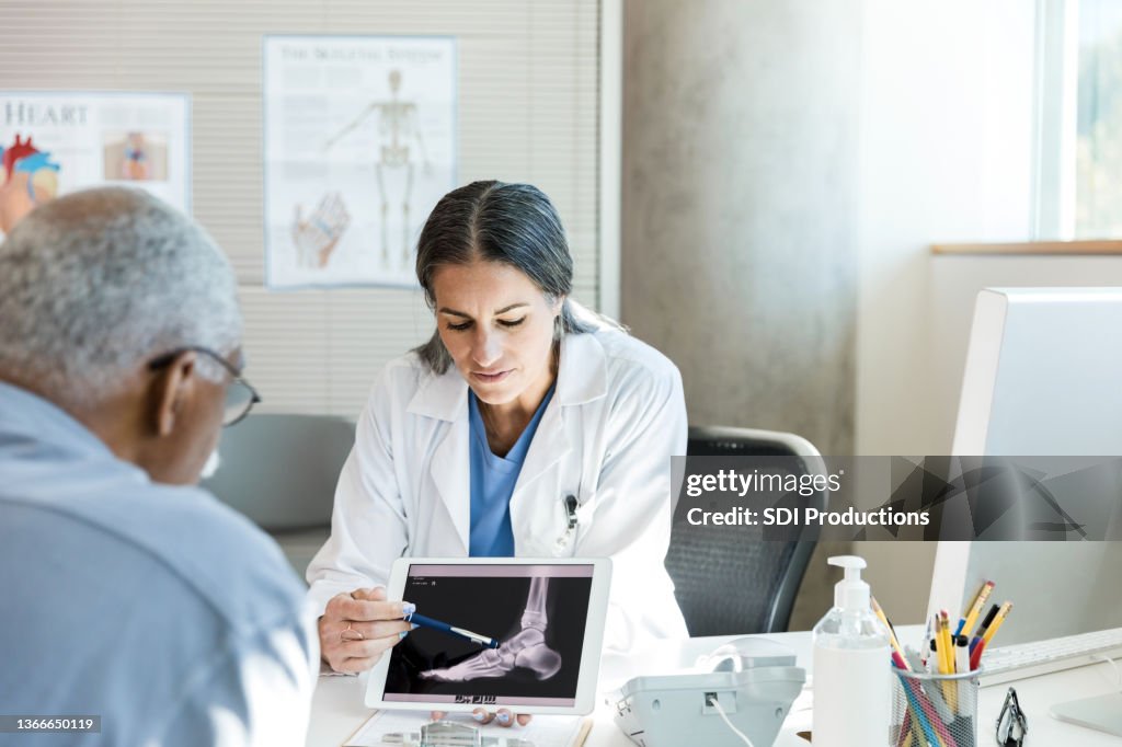 Orthopedist discusses senior patient's foot x-ray