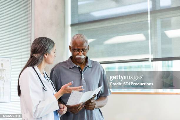 älterer mann bespricht pflegemöglichkeiten mit arzt - doctor stock-fotos und bilder