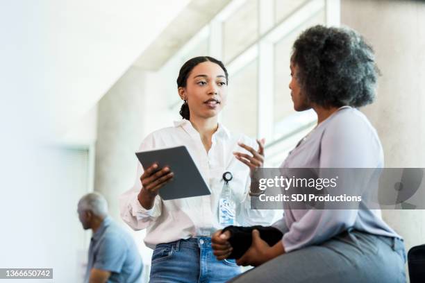 gestes du physiothérapeute tout en posant des questions à la femme sur les blessures - character stock photos et images de collection