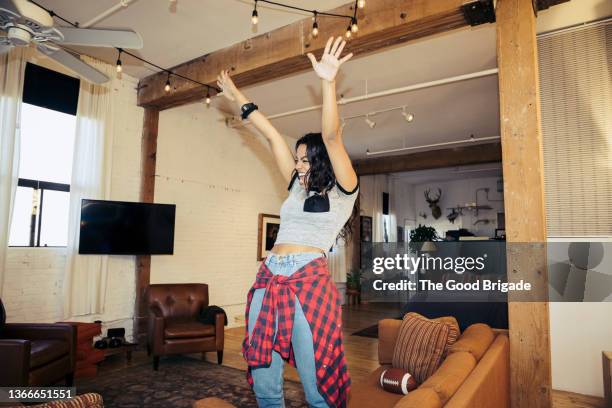 woman cheering during football game in living room at home - american football on screen stockfoto's en -beelden