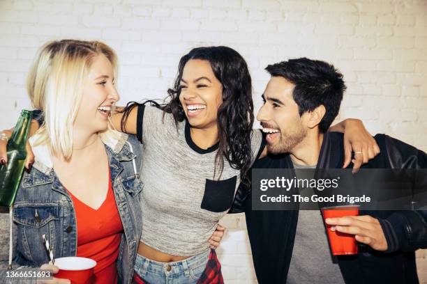 cheerful woman with arm around friends at party - the red party in los angeles stock-fotos und bilder