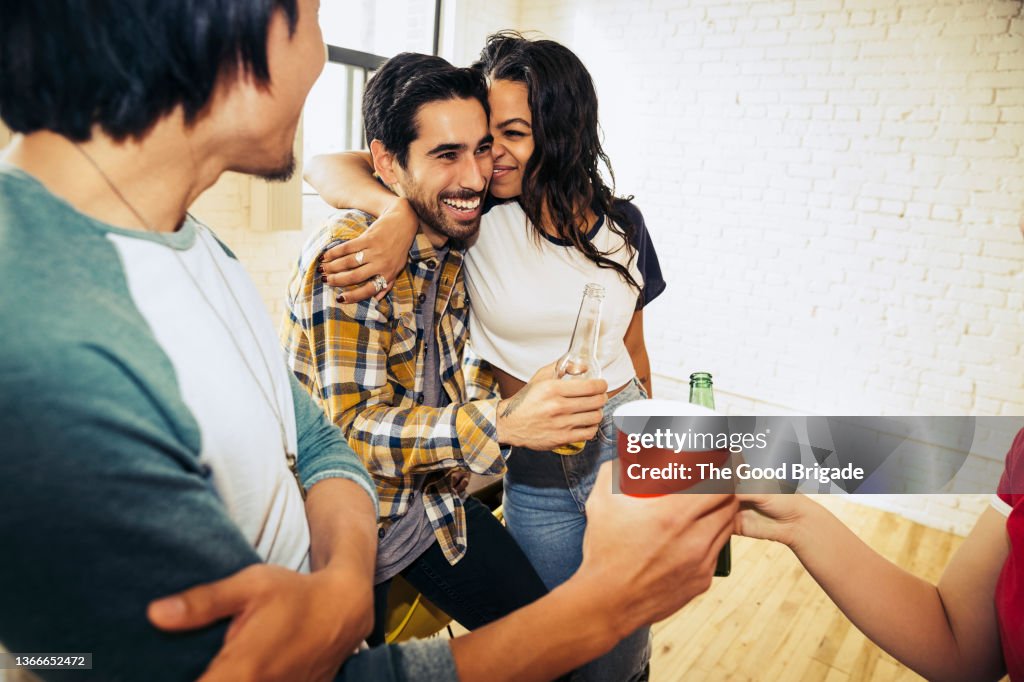 Woman sitting on boyfriend's lap during party