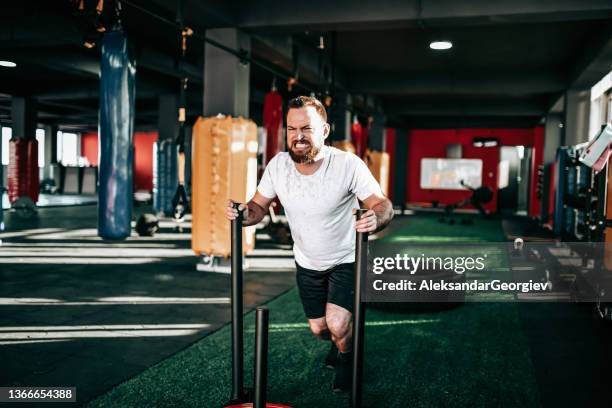 weight cart cross training by tough male athlete in gym - man pushing cart fun play stock pictures, royalty-free photos & images
