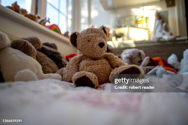 teddy bear on a bed - peluche foto e immagini stock