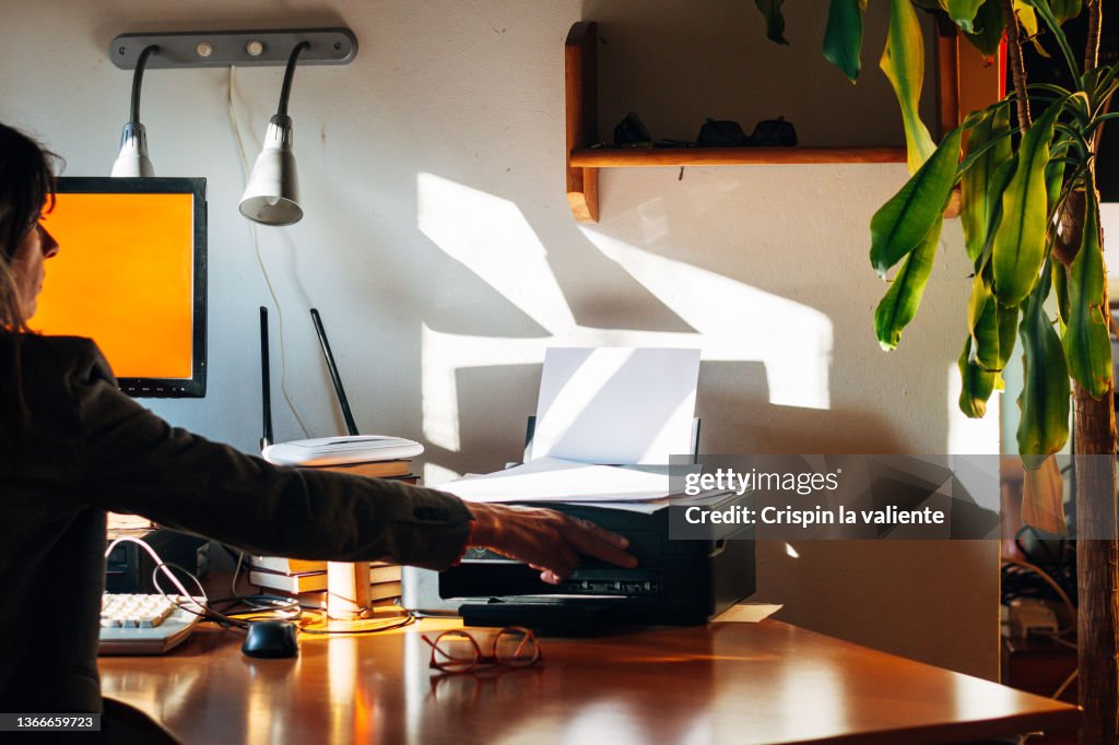 Woman using a small printer at home