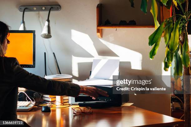 woman using a small printer at home - computer printer stock pictures, royalty-free photos & images
