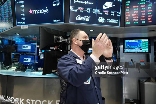 Trader claps on the floor of the New York Stock Exchange as the Dow Jones Industrial Average turns positive on January 24, 2022 in New York City....