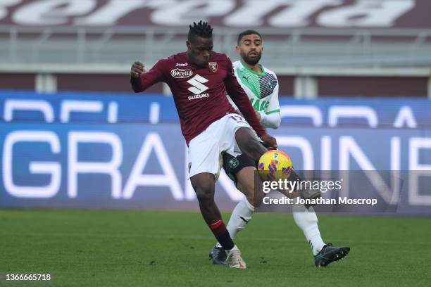 Wilfried Singo of Torino FC clears the ball from Gregoire Defrel of US Sassuolo during the Serie A match between Torino FC and US Sassuolo at Stadio...