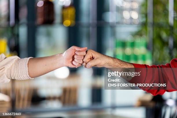 close up from young adults enjoying alternative greetings - welcoming in a nice eventlocation - students shaking hands stock-fotos und bilder