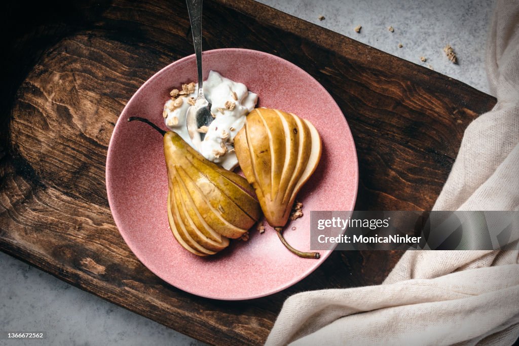 Pear and yogurt with muesli on plate