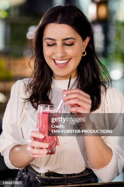 smiling, young and beautiful woman is drinking fresh juice with a metal straw - metal drinking straw stock pictures, royalty-free photos & images