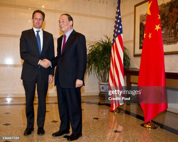 Treasury Secretary Timothy Geithner shakes hands with Chinese Vice Premier, Wang Qishan before attending a dinner at the Diaoyutai State Guesthouse...