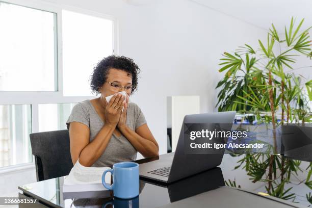 mujer con gripe que trabaja desde casa en una computadora portátil - frizzy fotografías e imágenes de stock
