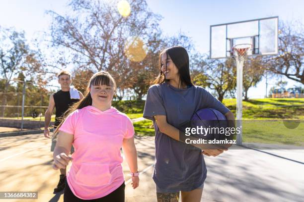 family walking off the court after basketball game with down's syndrome girl - play off stock pictures, royalty-free photos & images