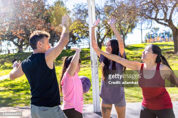 girl with down's syndrome playing basketball with her family high fives - east asian ethnicity stock pictures, royalty-free photos & images