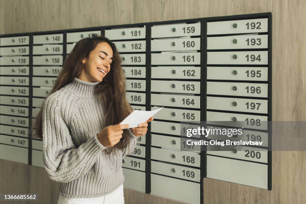 young cheerful woman receiving letter with good news by post. loan is repaid, the debt is paid - openbare brievenbus stockfoto's en -beelden