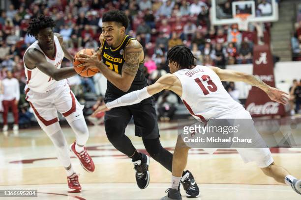 Ronnie DeGray III of the Missouri Tigers looks to maneuver the ball by Jahvon Quinerly of the Alabama Crimson Tide during the second half of play at...