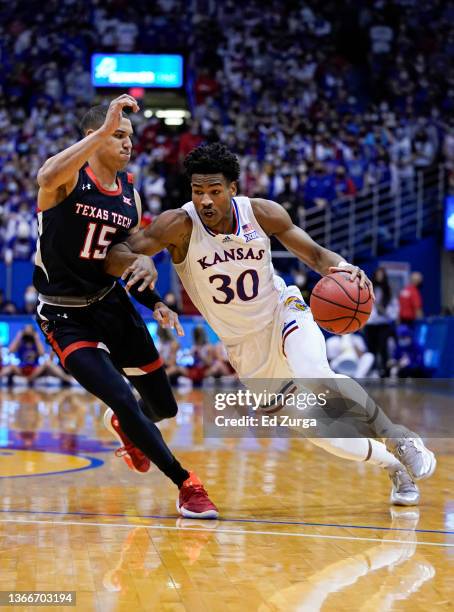 Ochai Agbaji of the Kansas Jayhawks drives against Kevin McCullar of the Texas Tech Red Raiders during the first half at Allen Fieldhouse on January...