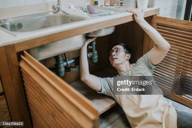 handsome asian plumber repair water pipe - leaking sink stock pictures, royalty-free photos & images