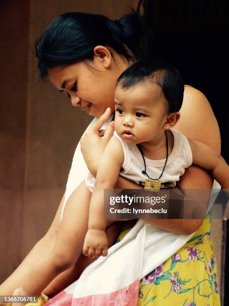 balinese mother holding her child - ubud, bali - bali women tradition head stock pictures, royalty-free photos & images