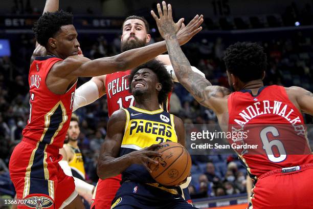Caris LeVert of the Indiana Pacers is defended by Herbert Jones, Nickeil Alexander-Walker and Jonas Valanciunas of the New Orleans Pelicans during...