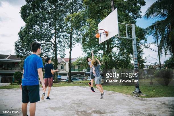 generation z asian chinese teenage boy challenge players and taking a shot playing basketball during weekend morning practicing basketball game with friends - rematar à baliza imagens e fotografias de stock