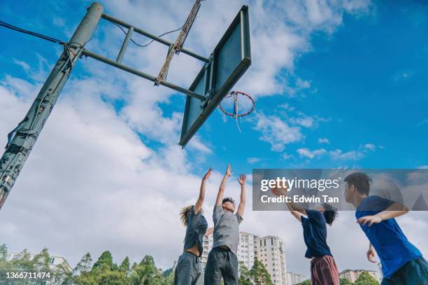 génération en contre-plongée z asiatique chinois adolescent défie les joueurs et prend un coup de feu en jouant au basket-ball pendant le week-end matin en pratiquant un match de basket-ball avec des amis - basket ball masculin photos et images de collection