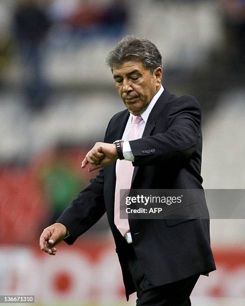 America´s coach Carlos Reinoso looks at his watch following a match against San Luis during their Mexican Apertura tournament in Mexico City on...