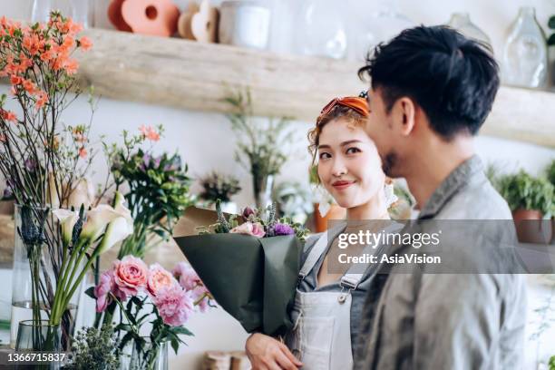 romantic young asian man buying flowers for his girlfriend in flower shop - asia lady selling flower stock pictures, royalty-free photos & images