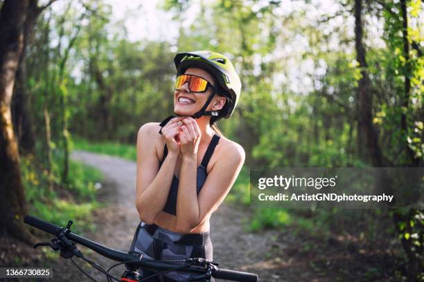 portrait of a smiling female mountain biker in the forest. - atlete stockfoto's en -beelden