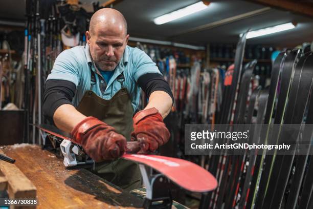 mann, der im skieinzelhandel und in der reparaturwerkstatt arbeitet. - wachs stock-fotos und bilder