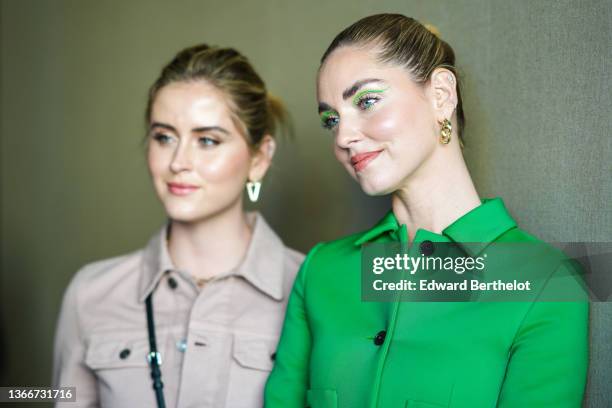 Valentina Ferragni wears gold and diamonds earrings, a gold large chain necklace, a beige denim jacket from Dior, a black shiny leather micro Vanity...