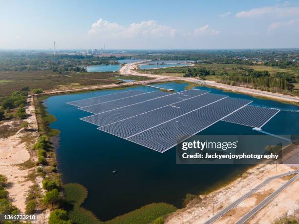 floating solar panels installed on water supply of neighbouring greenhouses, elevated view - biotech industries images stock pictures, royalty-free photos & images