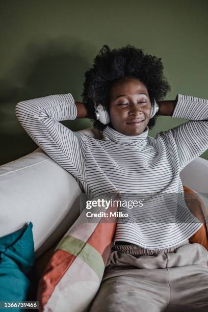 young african-american woman relaxing at home - hands behind head stock pictures, royalty-free photos & images