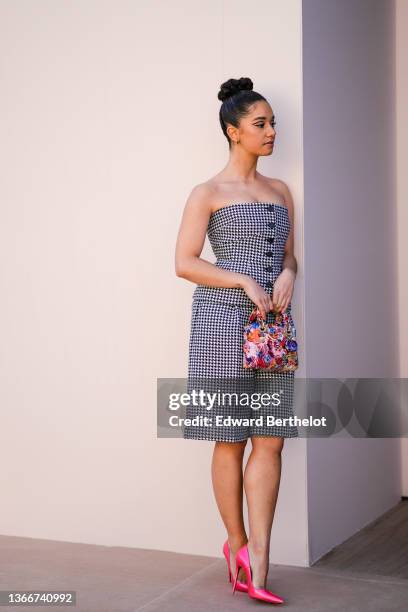 Lena Mahfouf aka Lena Situations wears gold earrings, a black and white houndstooth print pattern shoulder-off / buttoned t-shirt from Dior, matching...