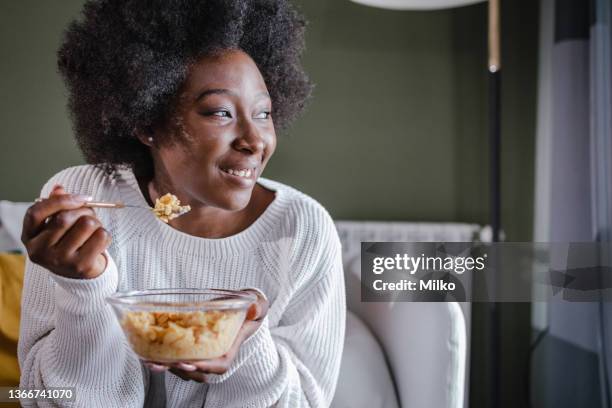 mujer feliz comiendo cereales para el desayuno en casa - breakfast cereal fotografías e imágenes de stock