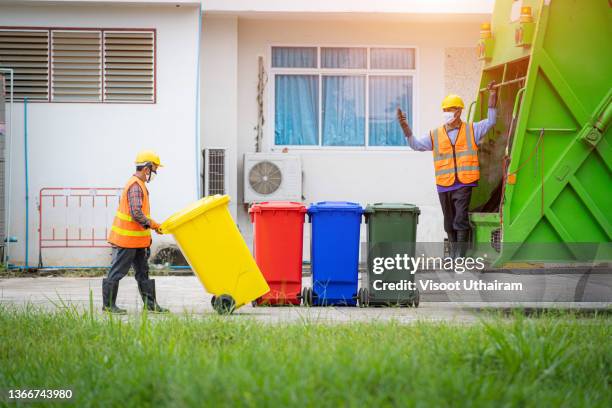 garbage man working at city,two workers loading mixed domestic waste in waste collection truck. - garbage truck driving stock pictures, royalty-free photos & images