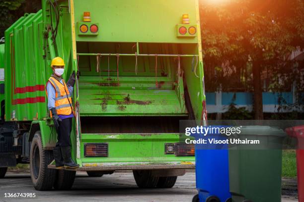 garbage man collector,garbage removal,loading garbage in the garbage truck. - vuilnisman stockfoto's en -beelden