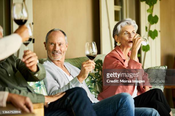 smiling man and woman drinking wine in restaurant - senior women wine stock pictures, royalty-free photos & images