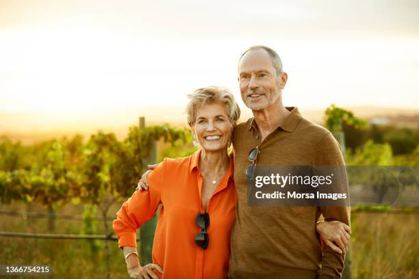 senior couple walking during wine tour at sunset - fond orange fotografías e imágenes de stock