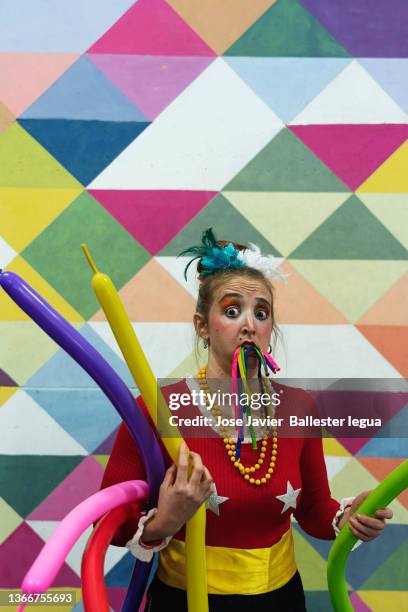 clown girl and circus performers performing before the show during warm-up exercises. comedian playing with balloons - funny clown stockfoto's en -beelden