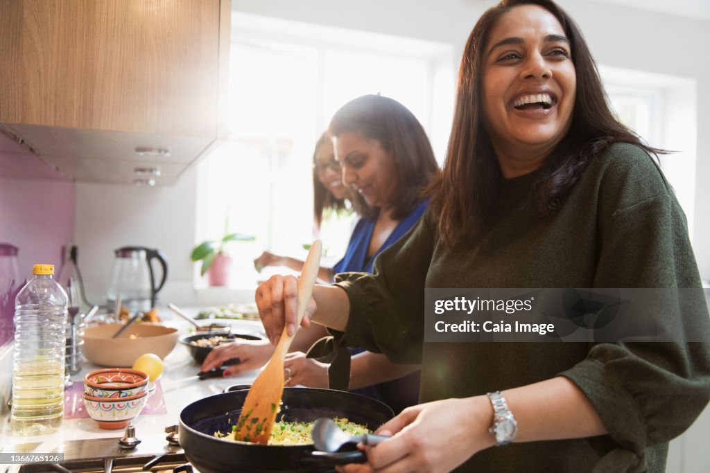 Happy Indian women cooking food in kitchen
