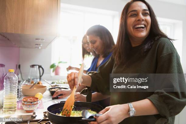 happy indian women cooking food in kitchen - indian art culture and entertainment ストックフォトと画像