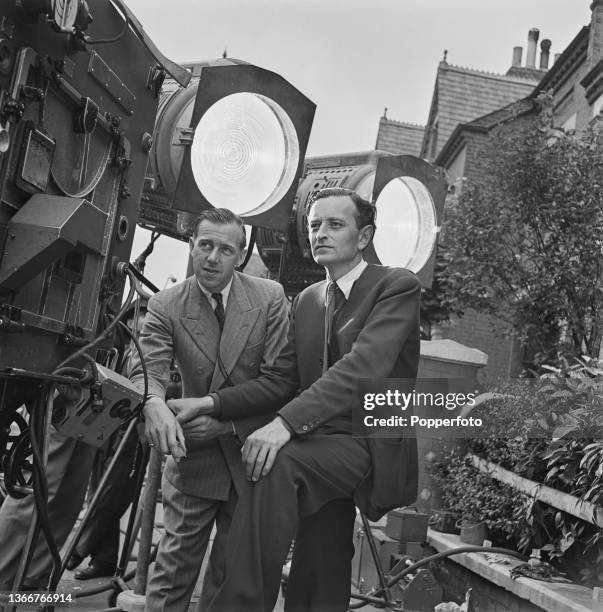 English film producer and cinematographer Ronald Neame stands on left with film director David Lean behind a film camera during production of the...