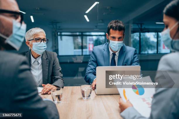 business persons with protective face masks on meeting in the office. - business meeting with masks stock pictures, royalty-free photos & images