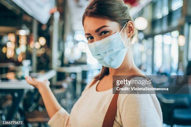 beautiful waitress with protective face mask working at a restaurant. - restaurant manager covid stock pictures, royalty-free photos & images
