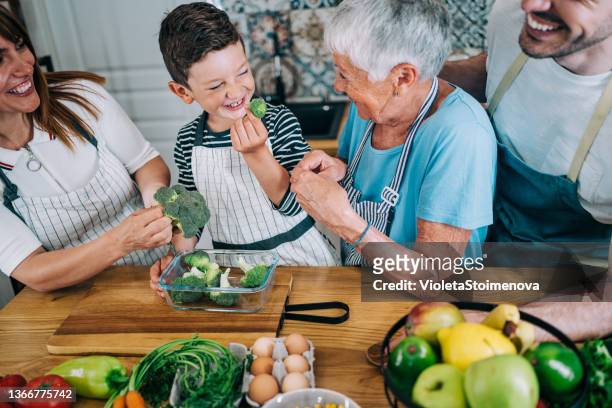 multi-generation family having fun in the kitchen. - crucifers stock pictures, royalty-free photos & images