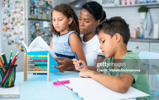 mother helping her children while studying. - stay at home mum stock pictures, royalty-free photos & images