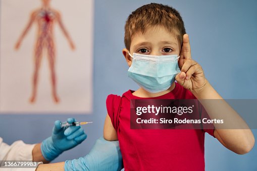 Child Receiving Injection Child Receiving The Vaccine And Looking At The Camera High-Res Stock ...