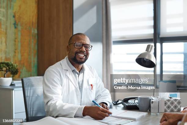 confident doctor at desk in hospital - doctor male laptop stock pictures, royalty-free photos & images